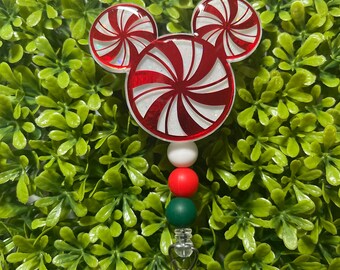 May include: A red and white peppermint candy cane shaped badge holder with a white, red, and green beaded chain.
