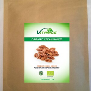 Może przedstawiać: Brązowa papierowa torebka zawierająca połówki orzechów pekan. Etykieta zawiera logo Vitanics, tekst ORGANIC PECAN HALVES, PRODUCT ORIGIN: MEXICO oraz wzmiankę o zastosowaniu w płatkach śniadaniowych, musli lub ciastach. Zawiera logo certyfikacji ekologicznej i EVERTRUST LTD.