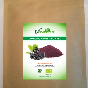 May include: A brown paper bag with a label that says "VITANICS ORGANIC ARONIA POWDER". The label also has a picture of a pile of purple powder and some dark berries. The label says "PRODUCT ORIGIN: EU" and "EVERTRUST LTD".