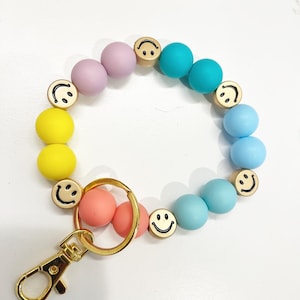 Llavero con muñequera con cuentas y sonrisa arcoíris