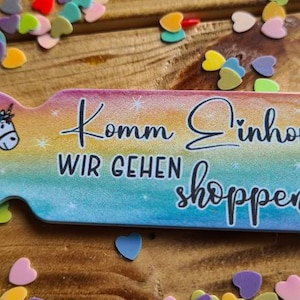 May include: A rainbow-colored key chain with a unicorn illustration and the text "Komm Einhorn Wir Gehen Shoppen".