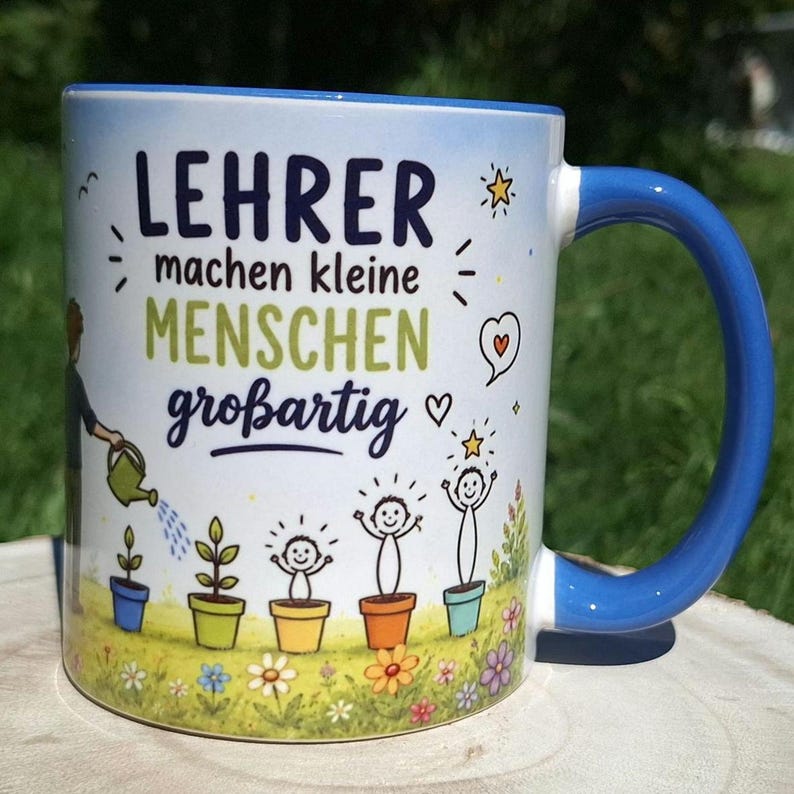 May include: White ceramic mug with a blue handle and rim. The mug features the German text "LEHRER machen kleine MENSCHEN gro&szlig;artig" with illustrations of plants and children. A person is watering the plants. Flowers are at the bottom.