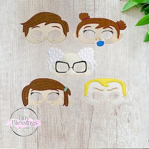 Puede incluir: Cinco máscaras de fieltro para niños, con diferentes personajes. Las máscaras son de color marrón, blanco y amarillo. Los personajes tienen diferentes expresiones, incluyendo una cara sonriente, una cara fruncida y una cara con un chupete.