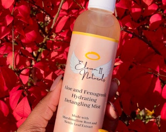 May include: A clear plastic bottle with a white spray top and a yellow label. The label says "Eleven 11 Naturals" and "Aloe and Fenugreek Hydrating Detangling Mist". The label also says "Made with Marshmallow Root and Nettle Leaf Extract" and "8 fl oz (237 ml)".