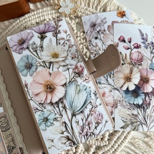 May include: A set of three floral patterned paper sheets with a delicate watercolor design. The sheets feature a variety of flowers in shades of pink, blue, and white.