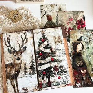 May include: A brown leather bound journal with a Christmas theme. The cover features a deer, a Christmas tree with red ornaments, and a winter scene. The journal is open to reveal a blank page.