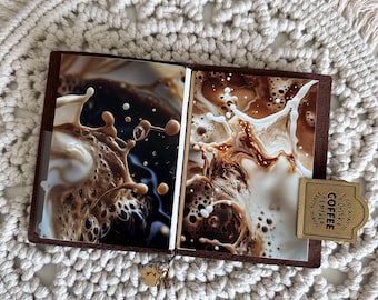 May include: A brown leather journal with two pages open, showing a close-up photo of coffee being poured. The journal has a gold charm attached to it with the words "Just wanna drink coffee & make things happen".