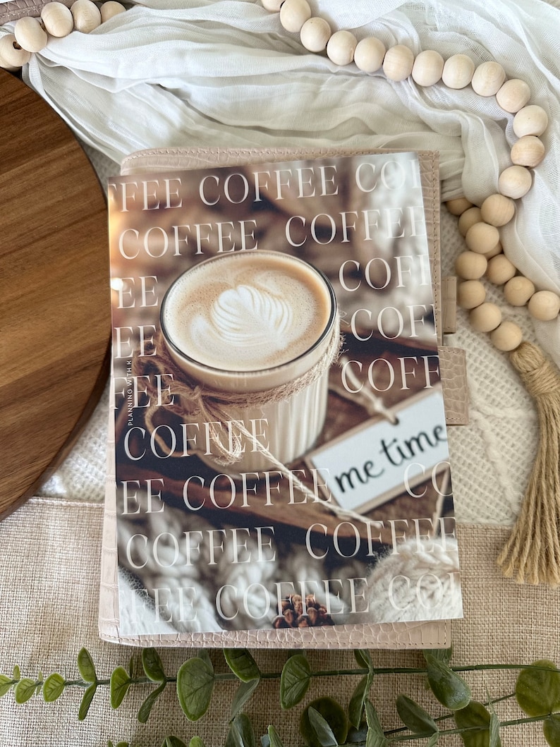 May include: A pink leather planner with a coffee cup and the words "FEE COFFEE CO" and "me time" printed on it.