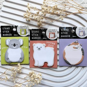 May include: Three packs of Stand Stick Marker sticky notes, each containing 30 sheets. The left pack features a gray koala on a lime green background, the center a white polar bear on a terracotta background, and the right a calico cat on a purple background.