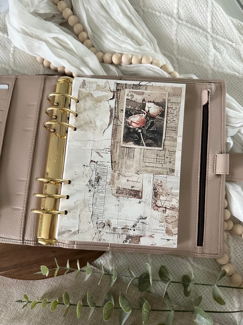 May include: A blush pink leather planner with gold rings and a white page with a vintage floral design and the text "Planning with..."