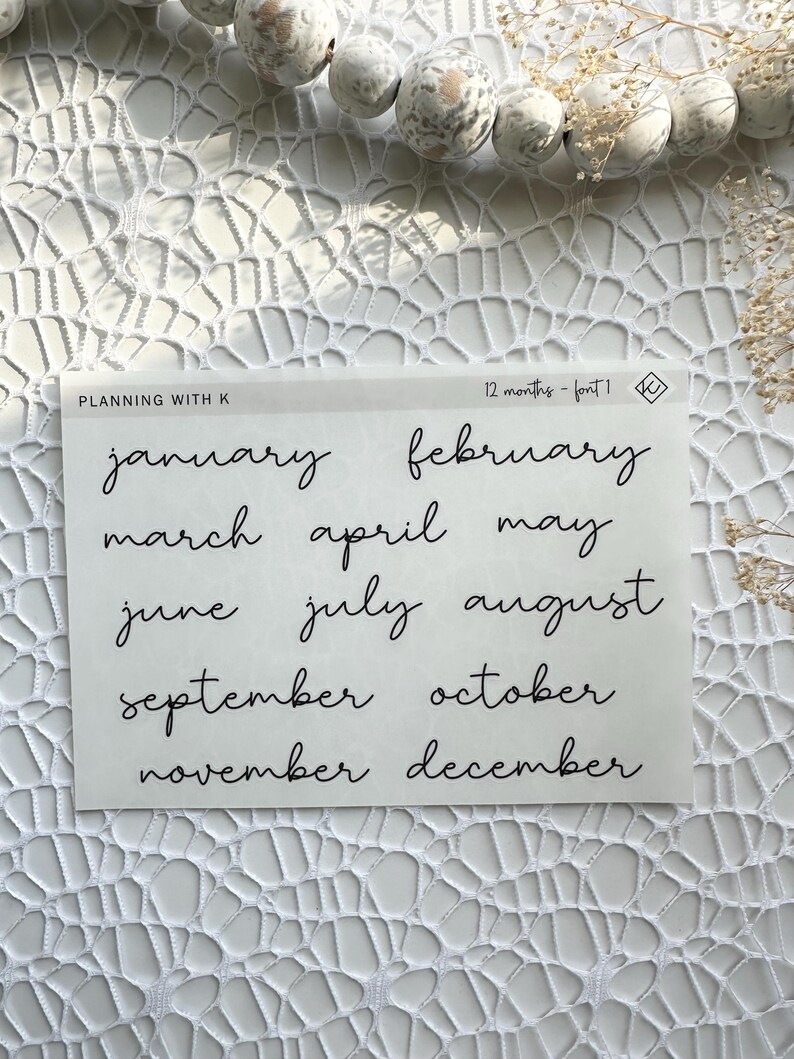 May include: A sheet of white paper with the months of the year written in black cursive script. The text reads "Planning with K 12 months - font 1".