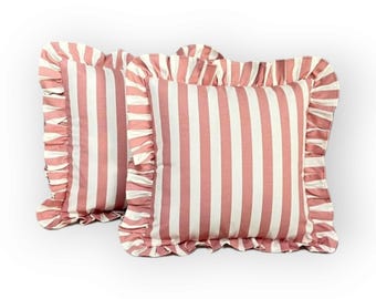 May include: Two pink and white striped pillow covers with ruffled edges.