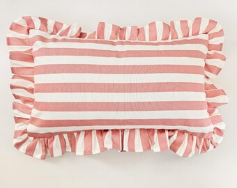 May include: A pink and white striped pillow with a ruffled edge. The pillow is made of a soft, cotton fabric and is perfect for adding a touch of color and texture to any room.