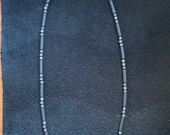 May include: A black and silver beaded necklace with a silver clasp.