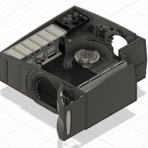 Op de afbeelding: Een 3D-geprint model van een ruimteschipinterieur, met daarin de cockpit, de zitruimte en het bedieningspaneel. Het model is gemaakt van grijs plastic en is gedetailleerd met verschillende texturen en kenmerken.