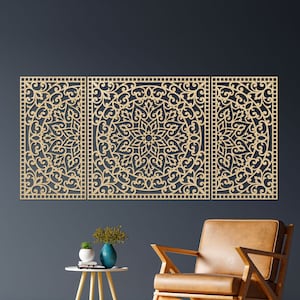 Può includere: Opera d'arte murale in legno a tre pannelli con intricati disegni floreali e a volute simmetriche. I pannelli, di colore beige chiaro, sono montati su una parete blu scuro. Una sedia e un tavolino di stile moderno sono in primo piano.