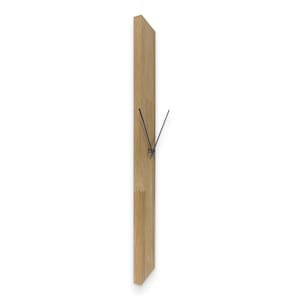 Op de afbeelding: Een rechthoekige houten wandklok met zwarte wijzers. De klok is gemaakt van lichtgekleurd hout en heeft een minimalistisch ontwerp. De zwarte wijzers geven de tijd aan. De klok is aan een witte muur bevestigd.