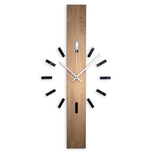 May include: A modern wall clock with a rectangular wooden face and silver hands. Black rectangular markers indicate the hours. The clock's design is minimalist and contemporary, suitable for home or office decor.