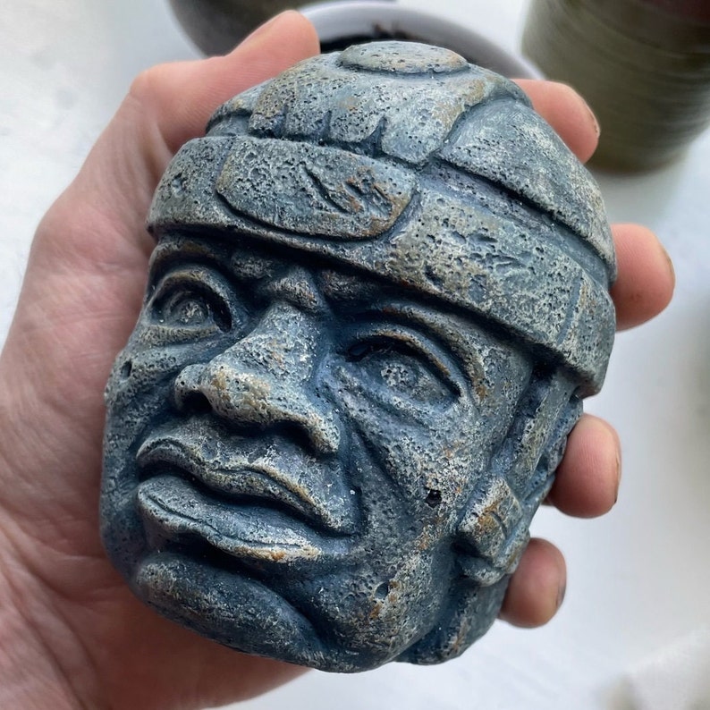 This is a scaled sculpture of the Olmec Head: Monument #1 "The King" from Mexico.
The sculpture has a nice weight and is given a blue stone coloring.  The sculpture has s beautiful texture that gives it a nice tactile feel.