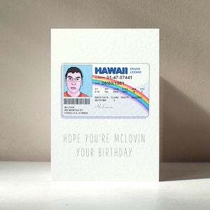 May include: A white birthday card with a cartoon illustration of a Hawaii driving licence. The card reads "HOPE YOU'RE MCLOVIN YOUR BIRTHDAY". The licence shows the name McLovin.
