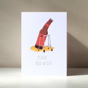 Könnte beinhalten: Eine humorvolle Grußkarte mit einer Cartoon-Illustration einer Bierflasche auf einem Rollator. Der Text lautet "Älter... Bud Wiser".
