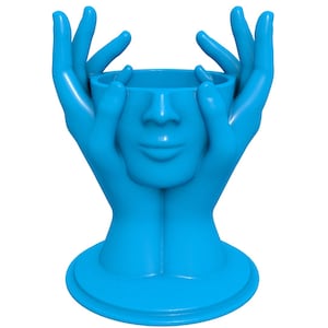 Könnte beinhalten: Eine blaue Keramikvase in Form von zwei Händen, die ein Gesicht halten. Die Vase ist ein modernes und abstraktes Design.