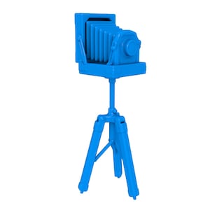 Puede incluir: Una cámara vintage azul sobre un trípode. La cámara tiene un diseño de fuelle y una lente con un obturador.