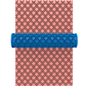 Pode incluir: Um rolo de plástico azul com um padrão de diamante repetido. O rolo é usado para criar um padrão em uma superfície rosa.