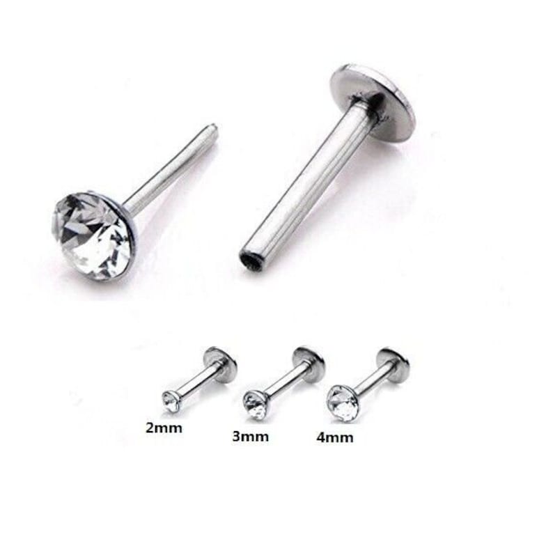 May include: Three silver nose rings with clear crystal stones. The rings are 2mm, 3mm, and 4mm in diameter.