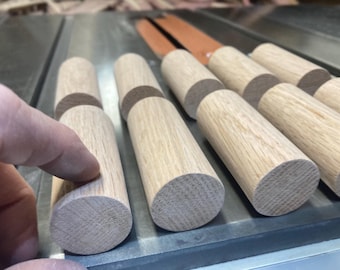 Red oak dowels — 2 pcs tapered per customer drawings, and 7 pcs at approximately 1-1/4” dia x 2” long.  Photos for reference only.