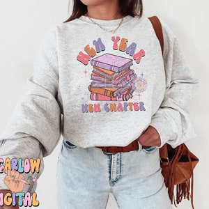 May include: A grey sweatshirt with a stack of books and the text "New Year New Chapter" in a colourful retro font.