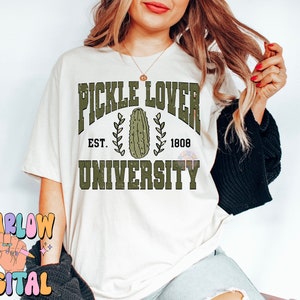 May include: White t-shirt with a green graphic that says "Pickle Lover University" with a pickle image and the text "Est. 1808".