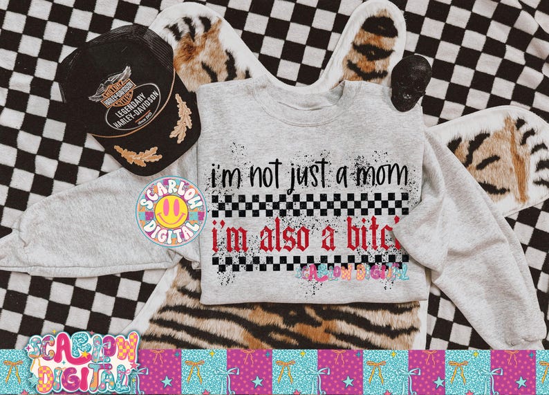 May include: A light gray sweatshirt with the text "I'm not just a mom, I'm also a b*tch" in black and red. A black Harley-Davidson hat and a skull are also visible. The background is a mix of checkered and animal print.