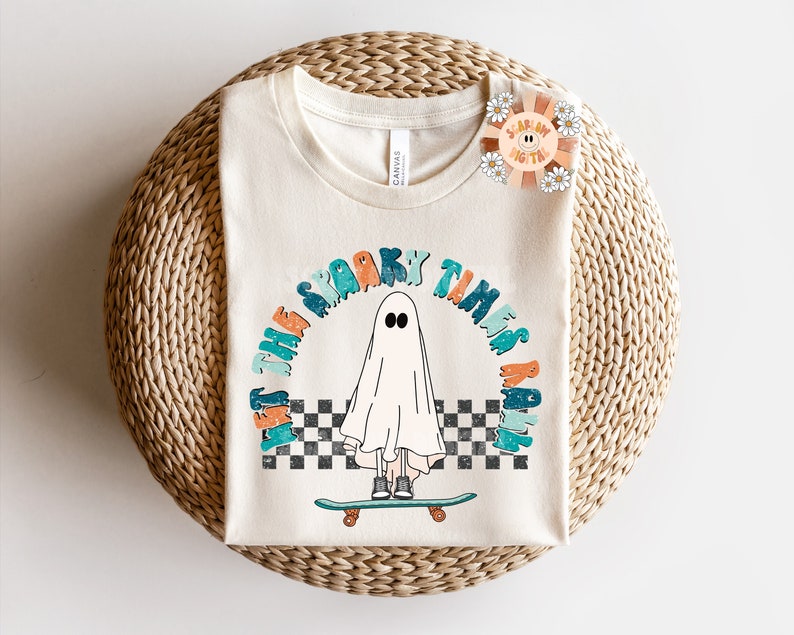 May include: A white t-shirt with a graphic of a ghost skateboarding and the text "Let the spooky times roll".