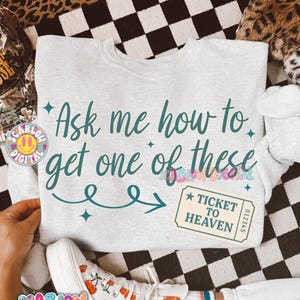May include: Light gray sweatshirt with the text "Ask me how to get one of these" in teal script. A "Ticket to Heaven" graphic is on the right. A pair of white sneakers with orange designs are at the bottom.