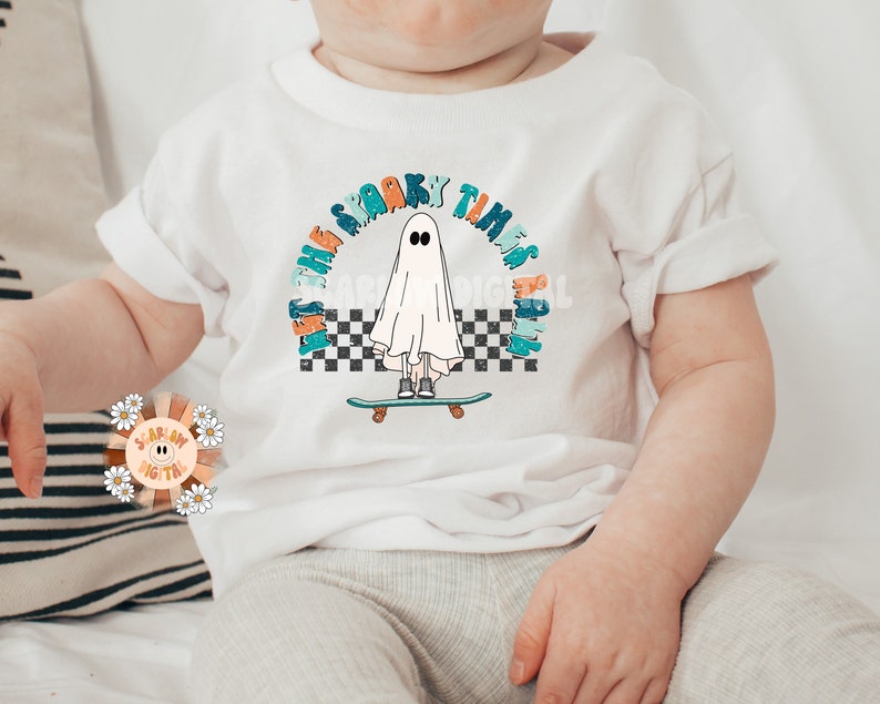 May include: White baby t-shirt with a graphic of a ghost skateboarding with the text "Let the spooky times roll" in a rainbow arch.