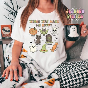 May include: White t-shirt with the text "Things that make me happy" and illustrations of pumpkins, bats, skulls, black cats, graveyards, ghosts, witches, and candy.