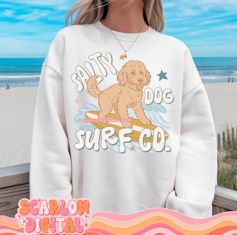 May include: White sweatshirt with a graphic of a dog surfing on a surfboard. The text "Salty Dog Surf Co." is printed on the sweatshirt.
