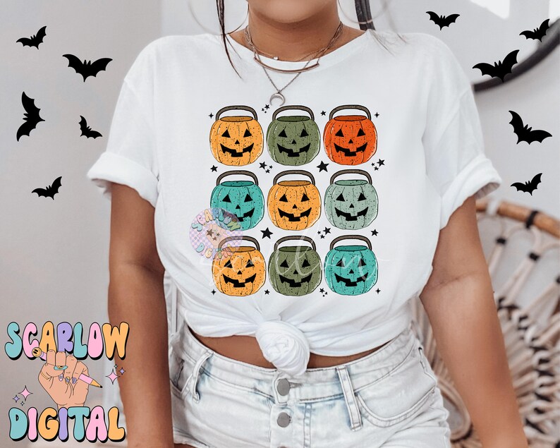 Puede incluir: Camiseta blanca con un patr&oacute;n de nueve cubos de calabaza de Halloween de colores. Los cubos est&aacute;n dispuestos en tres filas de tres. Cada cubo tiene un color diferente y una expresi&oacute;n facial diferente.