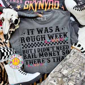 May include: A gray t-shirt with the text "IT WAS A ROUGH WEEK BUT I DIDN'T NEED BAIL MONEY SO THERE'S THAT". The image also includes a black t-shirt with "LYNYRD SKYNYRD" text, white boots, and camouflage pants.