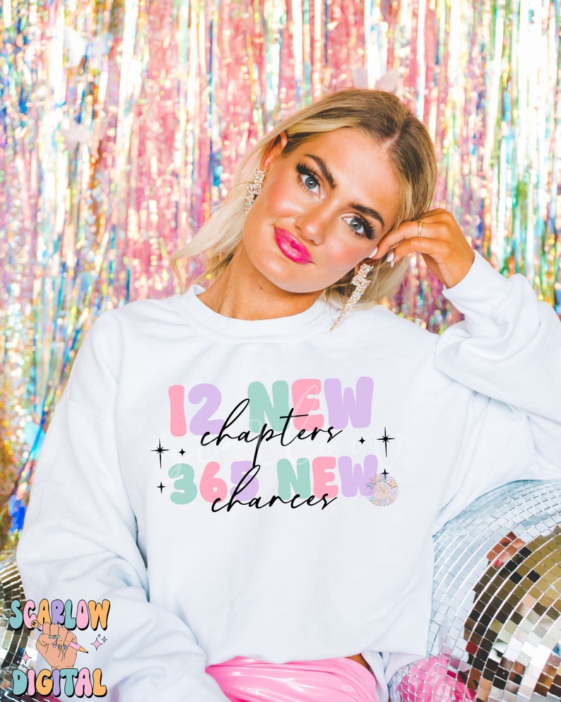 May include: White sweatshirt with a colorful graphic design that says "12 new chapters + 365 new chances".