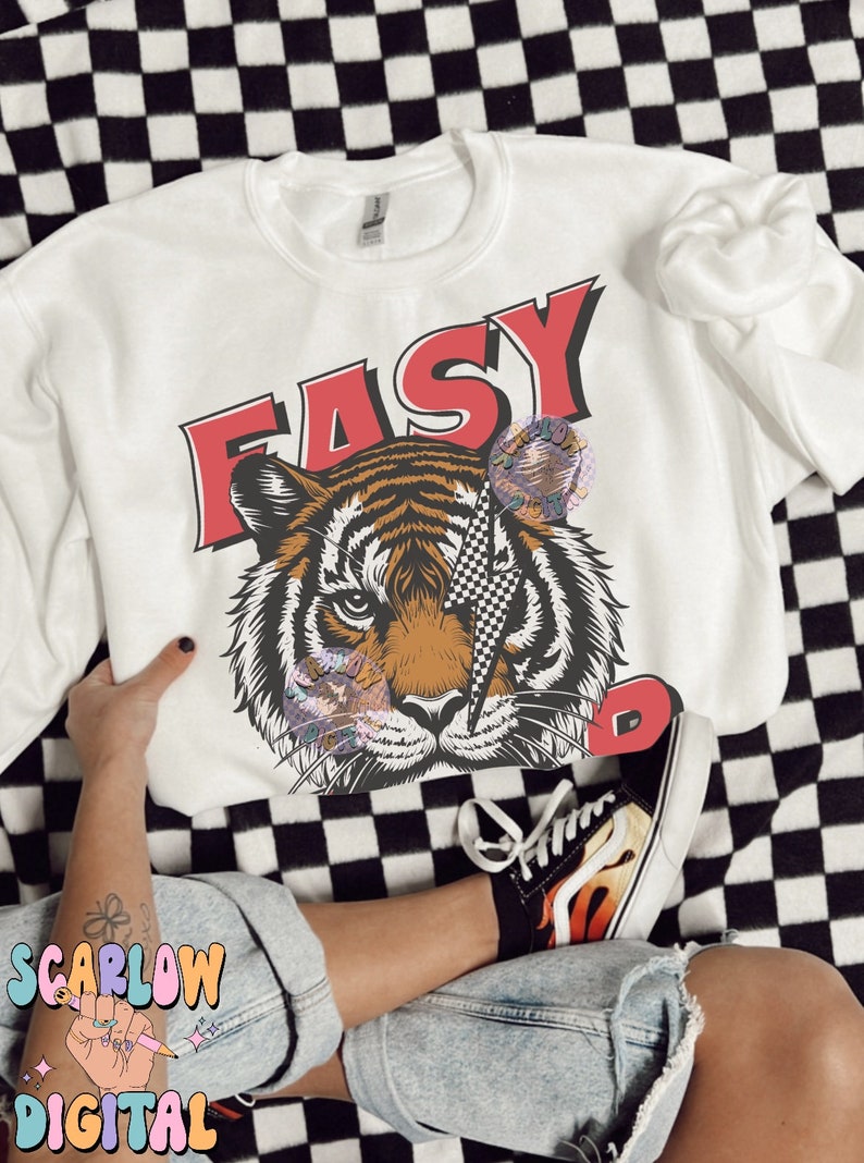 Puede incluir: Sudadera blanca con un gr&aacute;fico de tigre y la palabra "EASY" en letras rojas. El tigre tiene un rayo de color blanco y negro a cuadros sobre su ojo.