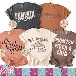 Può includere: Cinque magliette a tema autunnale in vari colori. Le magliette presentano testi come "Pumpkin Season", "It's Fall Y'all", "All Booked for Fall" e "Pumpkin Patch & Chill". Alcune magliette hanno grafiche di zucche.