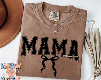 May include: A brown t-shirt with the word "MAMA" in black block letters and a black bow underneath. The shirt has a distressed look and is made of a soft, comfortable fabric.