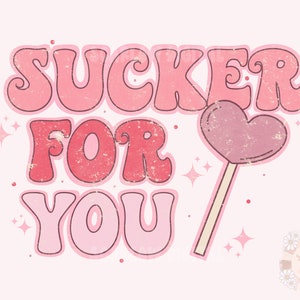 Może przedstawiać: R&oacute;żowa i czerwona grafika z tekstem "SUCKER FOR YOU" w retro stylu czcionki. Po prawej stronie grafiki znajduje się r&oacute;żowy lizak w kształcie serca.