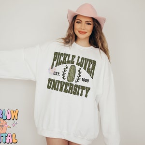 May include: White sweatshirt with a green graphic that says "Pickle Lover University" with a pickle image and the text "Est. 1808".