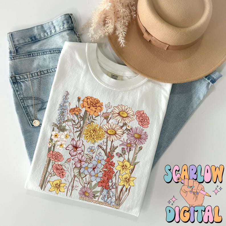 May include: White t-shirt with a floral print featuring a variety of flowers in shades of pink, yellow, orange, and blue. The text "SCARLOW DIGITAL" is visible in the bottom right corner of the image.