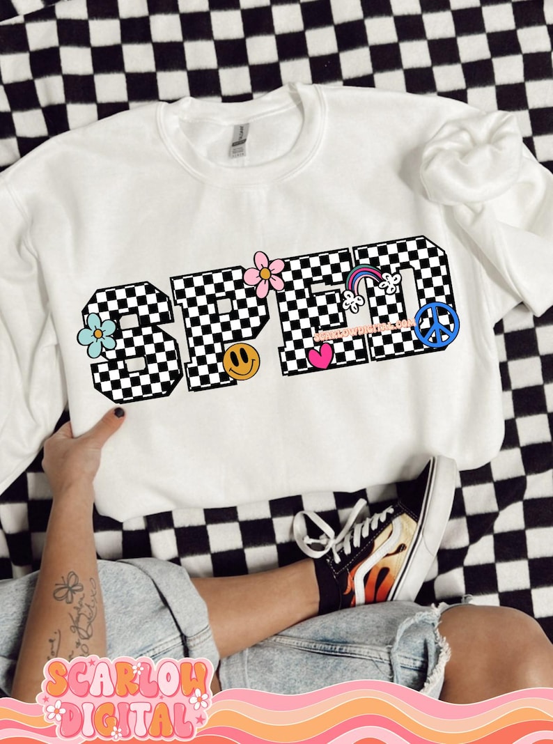May include: White sweatshirt with the word "SPED" in black and white chequered font. The letters are decorated with colourful flowers, a rainbow, a peace sign, a smiley face, and a heart.