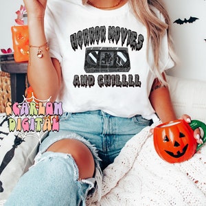 May include: A white t-shirt with the text "Horror Movies and Chilll" in black dripping letters. A black and white image of a VHS tape is in the center of the text.
