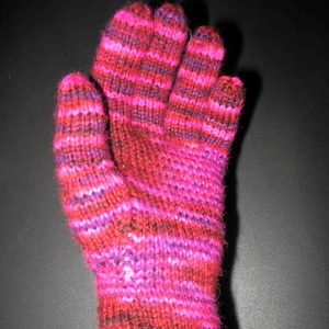 Puede incluir: Un par de guantes de punto a rayas rosa y morado. Los guantes están hechos con un hilo suave y cálido y tienen un ajuste cómodo.